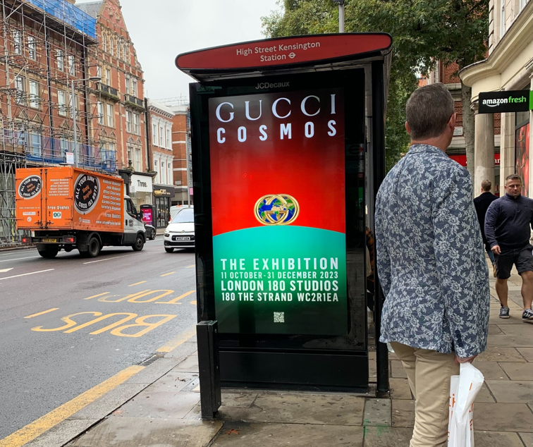 Bus shelter screen at High Street Kensington stop advertising Gucci Cosmos exhibition